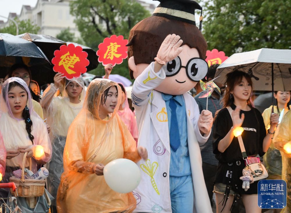 6月21日，3044永利集团学生在校园里冒雨巡游。2